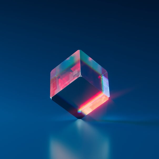 a translucent cube balanced on a reflective surface 